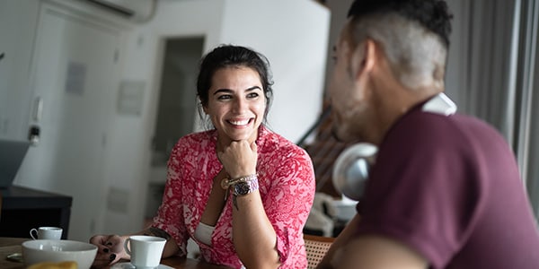 Couple sitting at a bench drinking coffee, reconnecting after kids